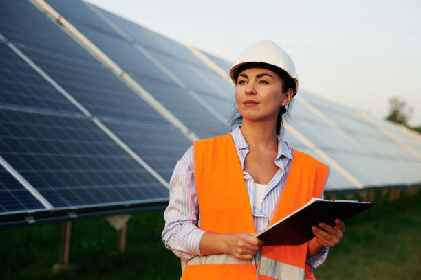 istock Checking the data, with notepad. Female worker engineer in uniform is near solar panels 2179160030