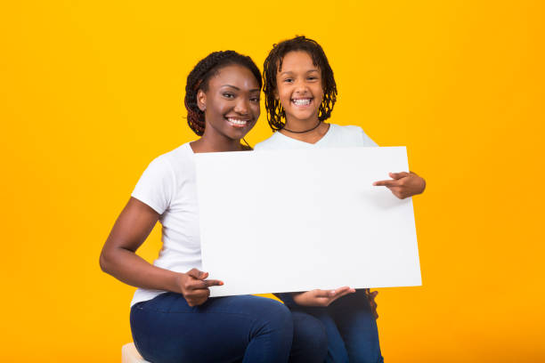 istock Happy family holding white placard at studio 2179162119