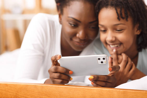 istock Afro mom and kid watching video on iPhone 11 pro max 2179162220