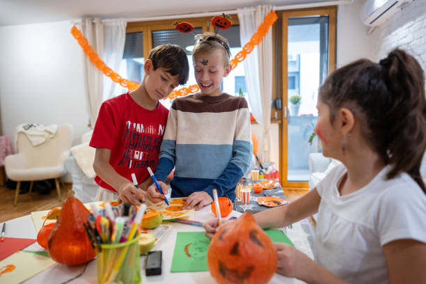 istock Creative kids make paper pumpkin decorations for Halloween 2179162331