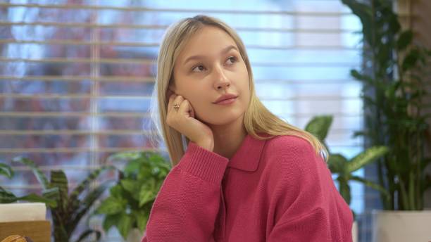 istock A young woman in a bright indoor setting reflects thoughtfully, surrounded by plants and light 2179164924