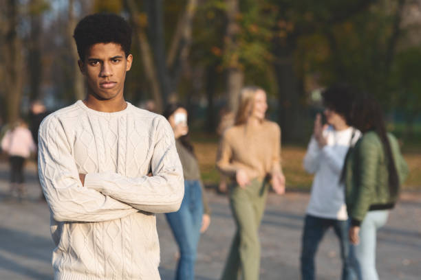 istock Depressed black guy standing apart from laughing students 2179167057