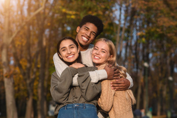 istock African guy hugging his pretty girlfriends, walking by park 2179167059