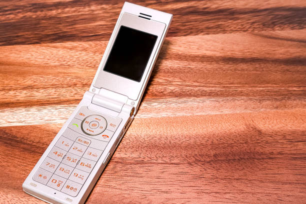 an asian man holding an old cellphone