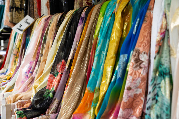 Colored fabrics with floral patterns are offered for sale on a market stall. Haagse Market in The Hague, Netherlands.