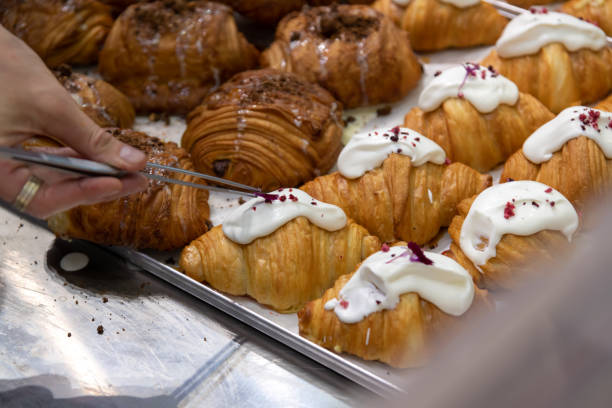 istock Cook putting edible flowers on croissants 2179170340