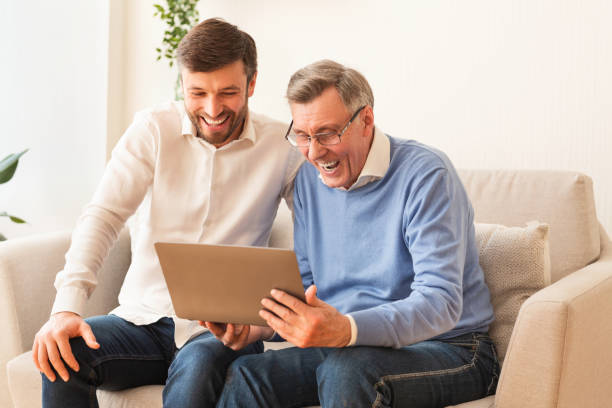 istock Middle-Aged Man And Elderly Father Using Laptop Sitting On Couch 2179171164
