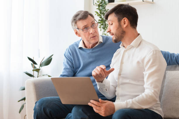 istock Son Teaching Senior Father Use Laptop Sitting On Couch Indoor 2179171286