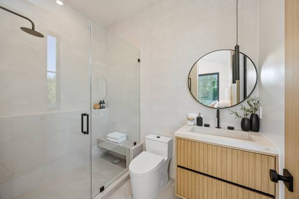 istock Modern bathroom with glass shower and wooden vanity. 2179171340