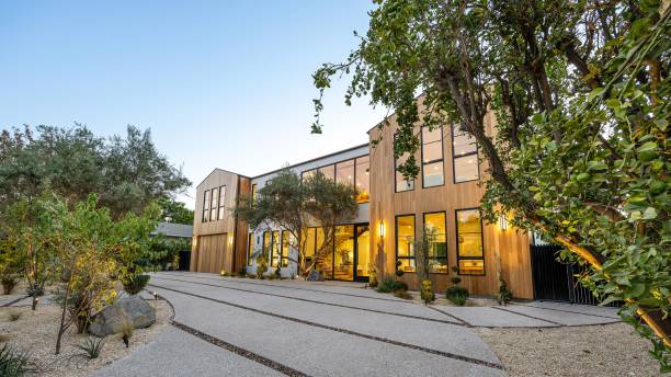 istock Modern house exterior with lush greenery and clear sky. 2179171519