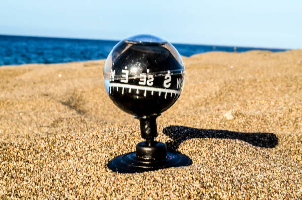 istock A black and clear compass sits on a sandy beach 2179179249