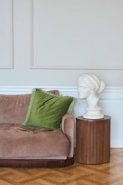 istock A classic style room. Interior decor. A brown sofa with cushions. Next to it is a bust made of plaster 2179184390