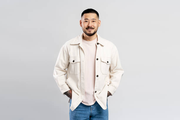 istock Young man smiling with hands in pockets on white background 2179185655