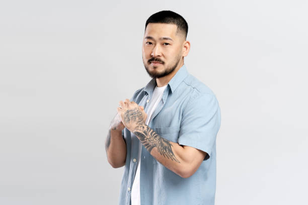istock Serious young man with tattoos is keeping his hands clasped 2179186945