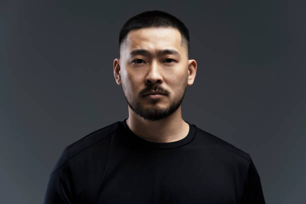 istock Serious young asian man with a goatee is posing on a grey background 2179189438