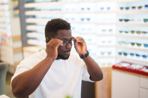 istock Young man is trying on prescription eyeglass frames at the optician's. 2179190860