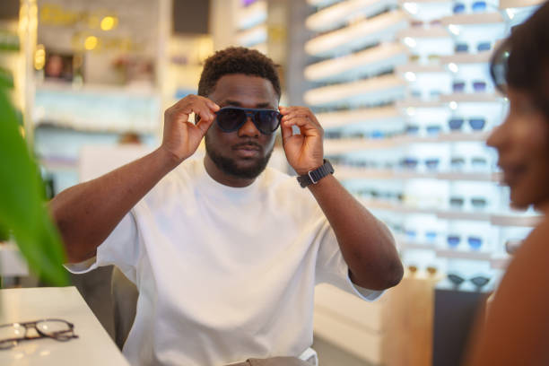 istock Young man trying on sunglasses in optic store. 2179191214