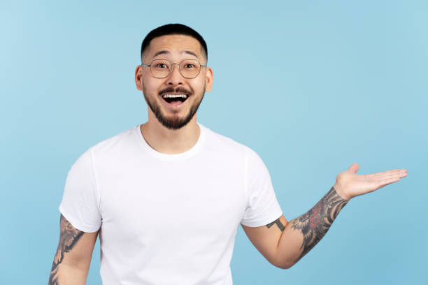 istock Happy man showing something with open hand gesture on blue background 2179192350