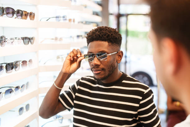 istock Young man trying on sunglasses in optic store. 2179194053