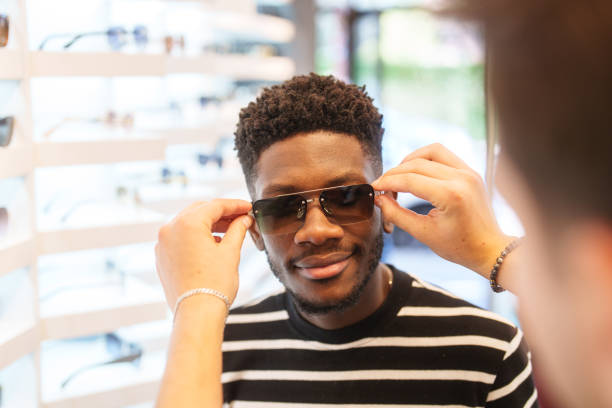 istock Young man trying on sunglasses in optic store. 2179195530