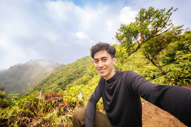 istock Man Embracing the Adventure, Facing Camera at Summit. Stunning Panoramic Landscape from Mountain Peak. 2179195977