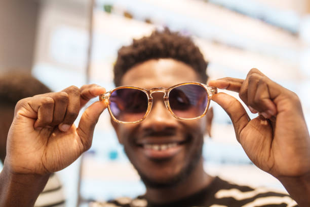 istock Young man trying on sunglasses in optic store. 2179196007