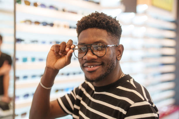 istock Young man trying a new eyeglasses on in optic store. 2179196481