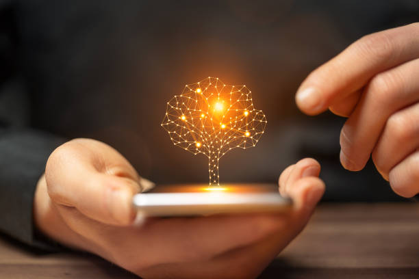 istock Artificial intelligence tree symbol on smartphone in the hand of a man 2179207565