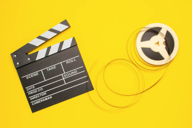 Film Clapperboard and Reel on Yellow Background: Cinematic Tools for Creative Projects
