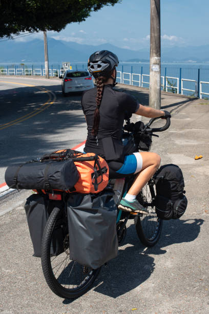 Young woman cycling with a cyclo-touring bike on the waterfront of Florianopolis in southern Brazil