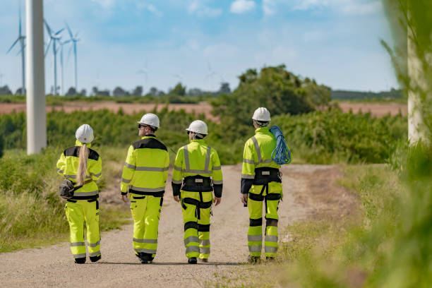 istock group of engineers in high visibility gear stands at a wind farm, observing several wind turbines. The image highlights teamwork, renewable energy, and the scope of wind power projects. 2179215900
