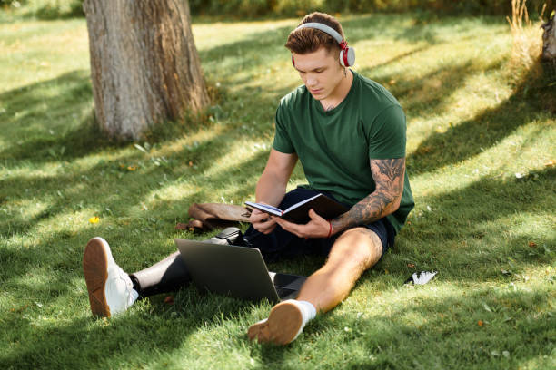 istock A young man with a prosthetic enjoys studying in a sunny park 2179222622