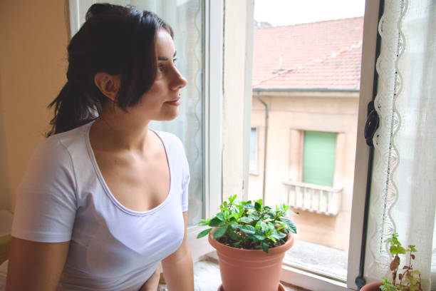 istock Cute girl thinks in front of a window 2179224889