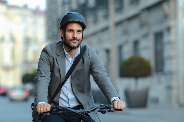 istock Tired businessman commuting on bicycle in urban setting with helmet 2179226027