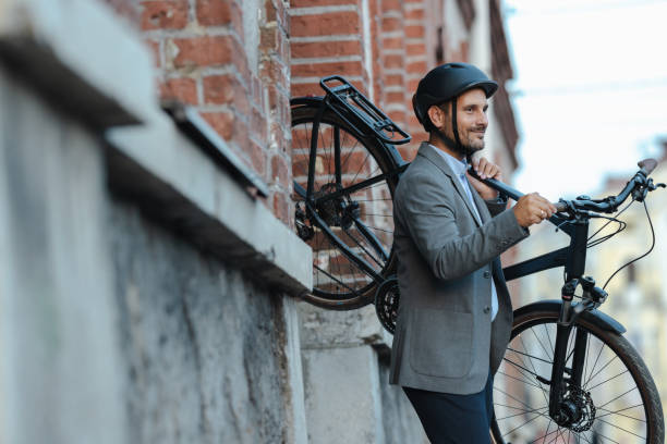 istock Young professional leaving building with bicycle in urban setting 2179226399