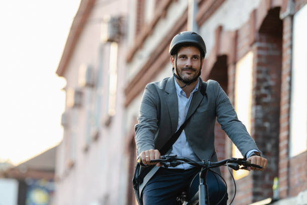 istock Tired businessman commuting on bicycle in urban setting with helmet 2179227660