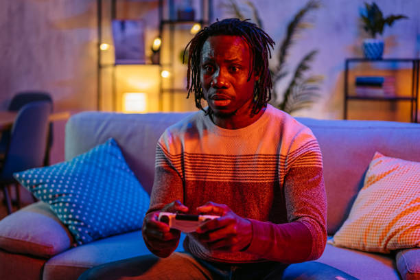 istock Young Man Playing Video Games At Home At Night 2179228868