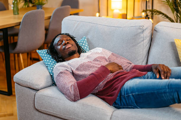 istock Young Man Sleeping On The Sofa At Home At Night 2179229969