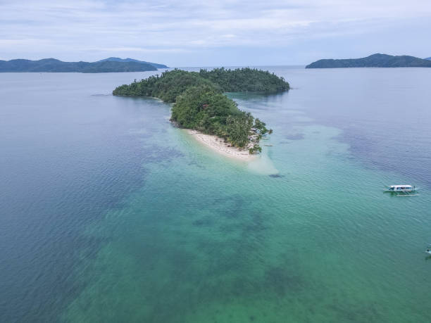 istock Small Tropical Island Surrounded by Clear Blue Waters 2179230071
