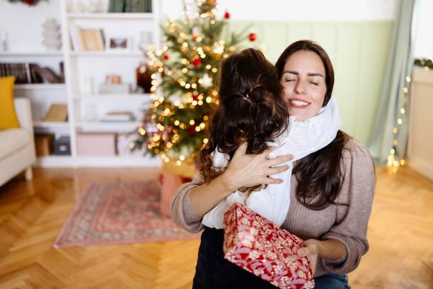 istock Mother and daughter hugging while celebrating Christmas 2179233660