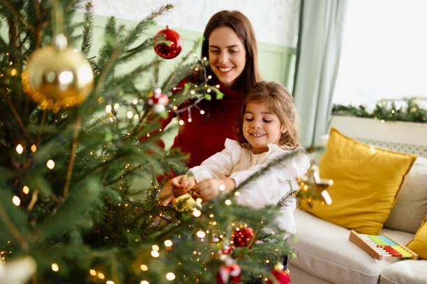 istock Mother and daughter decorating Christmas tree 2179233993