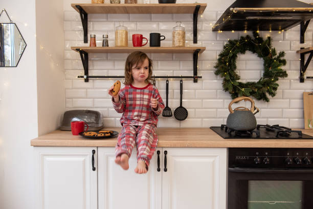 istock Child Enjoying Cookie in Festive Kitchen 2179235863