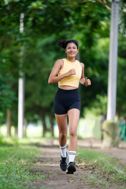 istock Beautiful young woman runner in a green park 2179246232