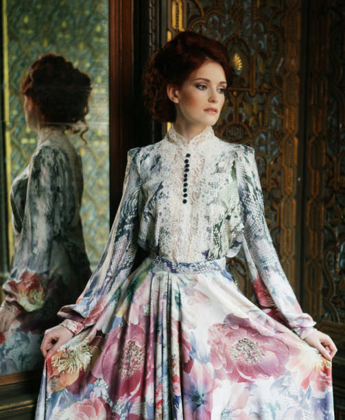 Young beautiful woman standing in the palace room with mirror.