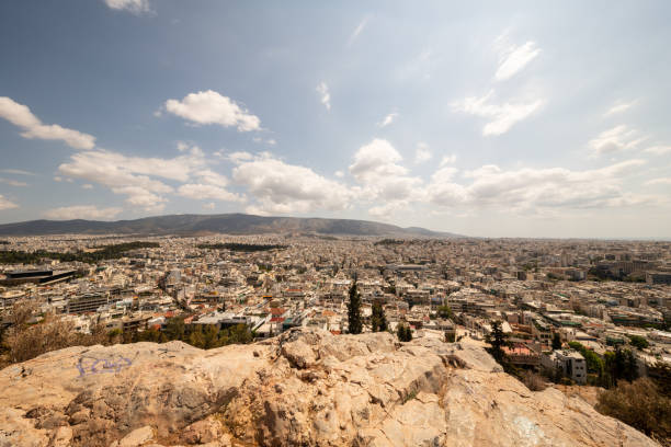 A view of the Athens skyline and mountains in the distance as viewed from atop Philopappos Hill on a beautiful summer day.