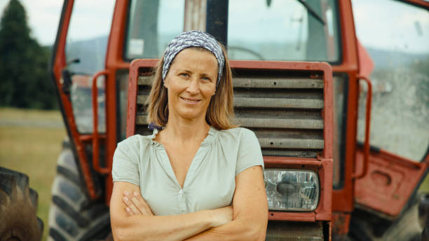istock Confident Female Farmer With Tractor in Rural Landscape 2179261228