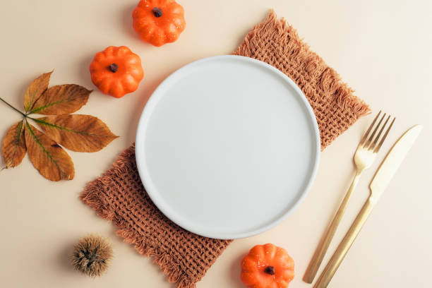 istock Empty plate, decorative pumpkins and chestnut leaf on neutral beige background. Autumn concept. Top view, flat lay, mockup 2179263171