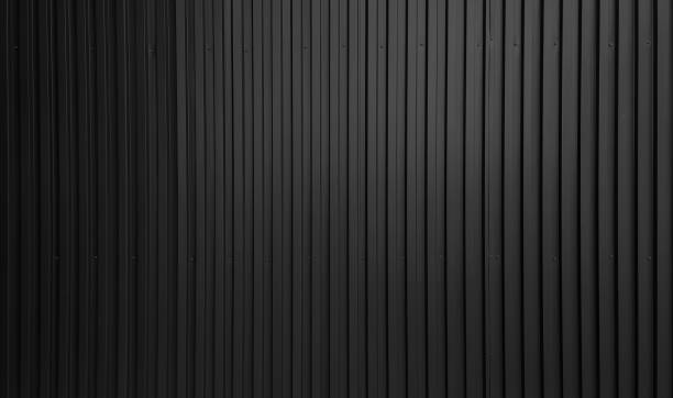 real black chrome corrugated metal sheet wall showing vertical pattern, bolts, screw. modern industrial dark black metal sheet wall facade. real black chrome corrugated metal sheet wall showing vertical pattern, bolts, screw. modern industrial dark black metal sheet wall facade. wide surface of aluminum wall texture use for design. corrugated metal fence ideas stock pictures, royalty-free photos & images