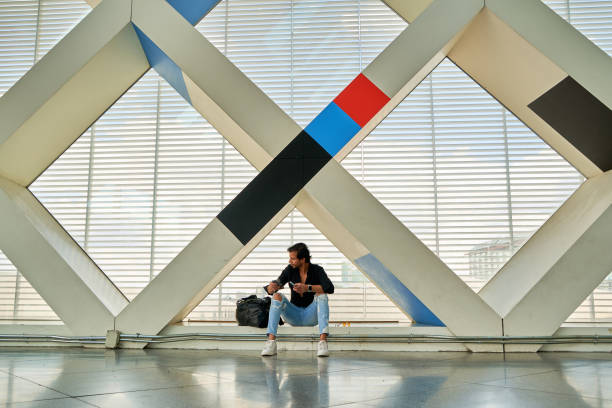 istock Man Sitting and Using Phone in Modern Building 2179277224