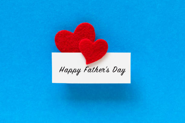 Red heart shapes attached to a white card with Happy Father’s day text on blue background.